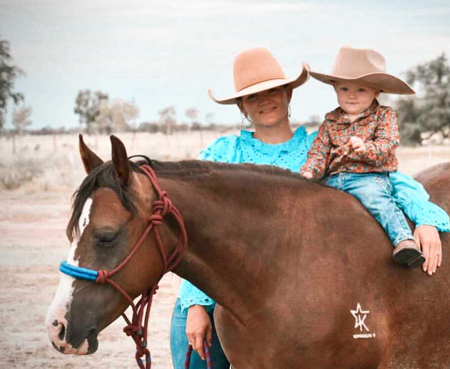 campdraft kid wearing unchained eight romper and onesie one a bay quarter horse ready to go campdrafting.