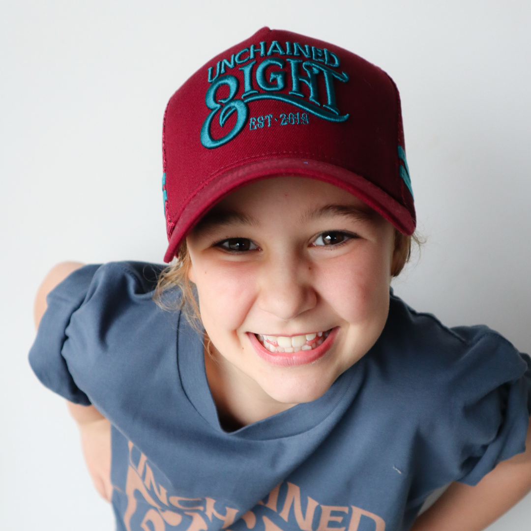 little cowgirl wearing aussie trucker cap baseball cap for unchained eight country and western wear clothing for cowgirl cowboy ringer ringers western buy from the bush cinch wrangler PBR mavricks western dusty creek trucker cap ariat cap on australian made cowhide rug youth wearing unchained eight tee